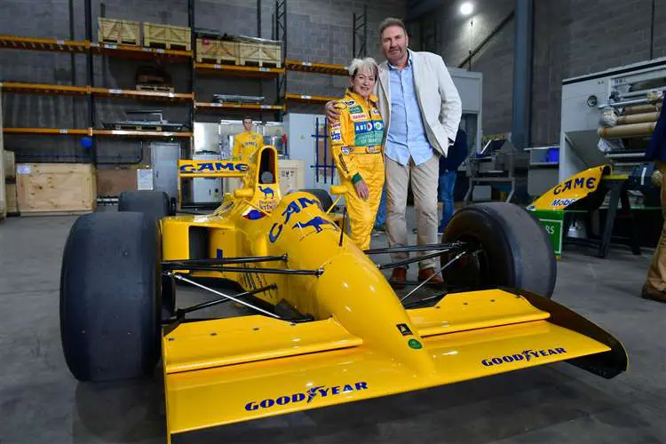 Andrew Morris, owner of International Export Packers, and Lorina McLaughlin stand beside a Lotus Formula One car at the International Logistics Centre during the company's Open Afternoon.