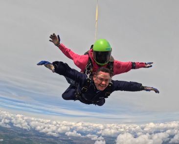 Craig Symonds mid-skydive during a charity jump for the Children’s Bereavement Centre, freefalling through the sky with a huge smile on his face.