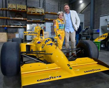 Andrew Morris, owner of International Export Packers, and Lorina McLaughlin stand beside a Lotus Formula One car at the International Logistics Centre during the company's Open Afternoon.